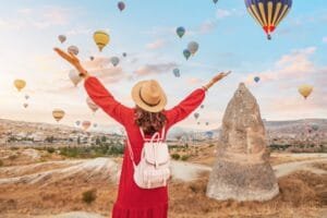 Woman enjoying hot air balloons in Cappadocia during sunrise