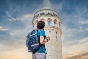 Solo traveler looking up at the historic Galata Tower in Istanbul