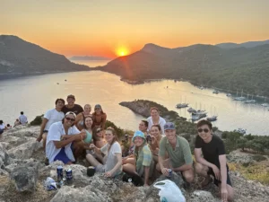 Group of young travelers at St Nicholas Island sunset during a Sail Turkey Blue Cruise