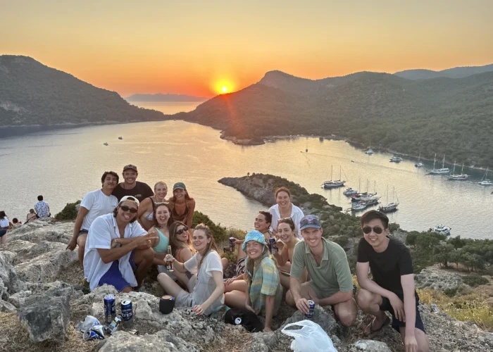 Group of young travelers at St Nicholas Island sunset during a Sail Turkey Blue Cruise