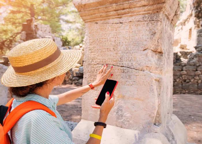 Close up of an ancient arch and reliefs at Ephesus site with tourists viewing
