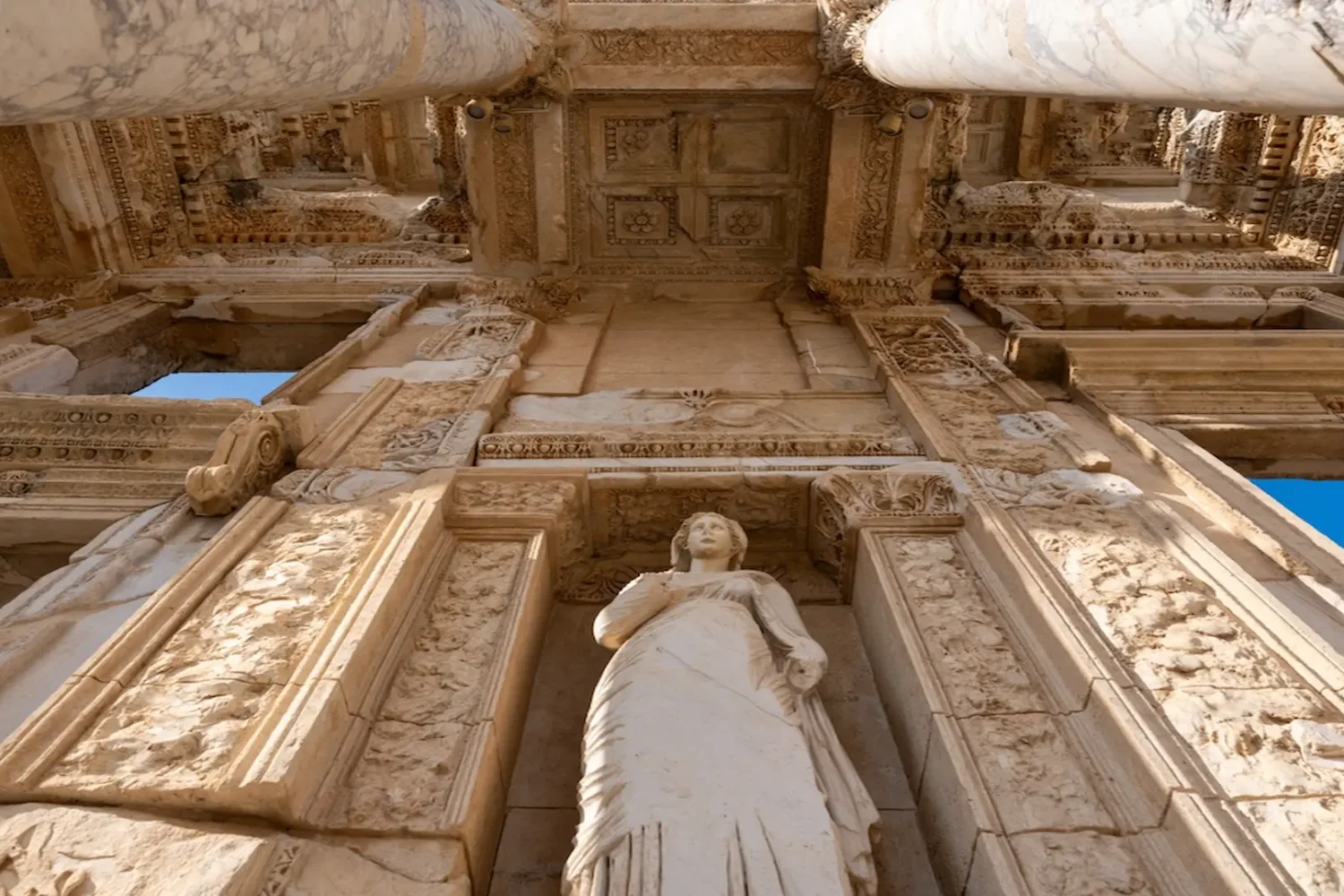 Marble statue at the facade of Celsus Library in Ephesus under blue sky