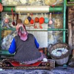 Local woman weaving carpets with colorful yarn in Bodrum village