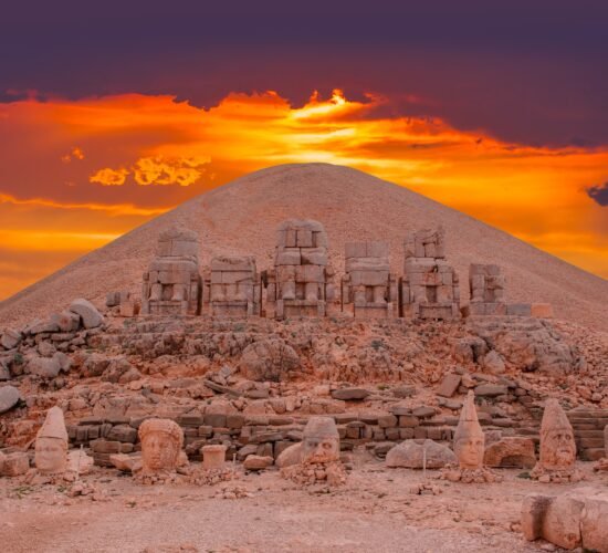 Sunset view behind ancient statues on Nemrut Mountain