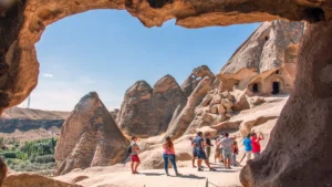 Tourists exploring Cappadocia’s fairy chimney rock formations