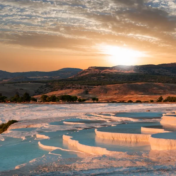 Golden sunset over Pamukkale travertines with blue thermal pools