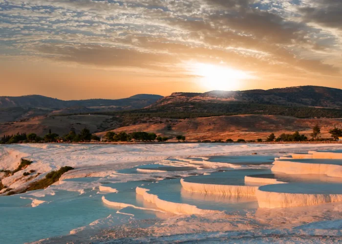 Golden sunset over Pamukkale travertines with blue thermal pools