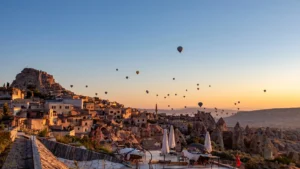 Sunset view of Uchisar Castle with hot air balloons in Cappadocia