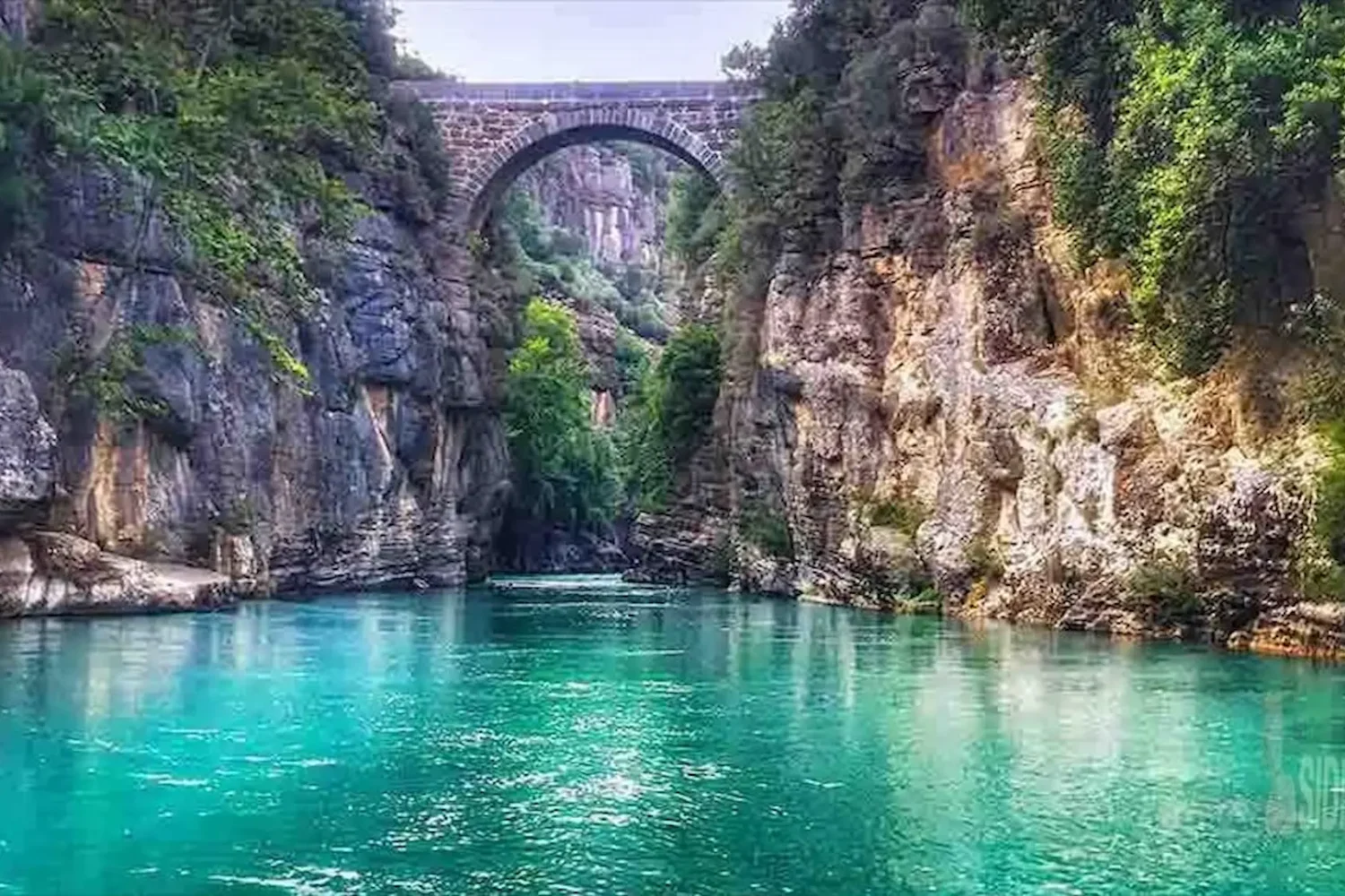 Ancient Roman stone bridge over turquoise river in Koprulu Canyon Antalya