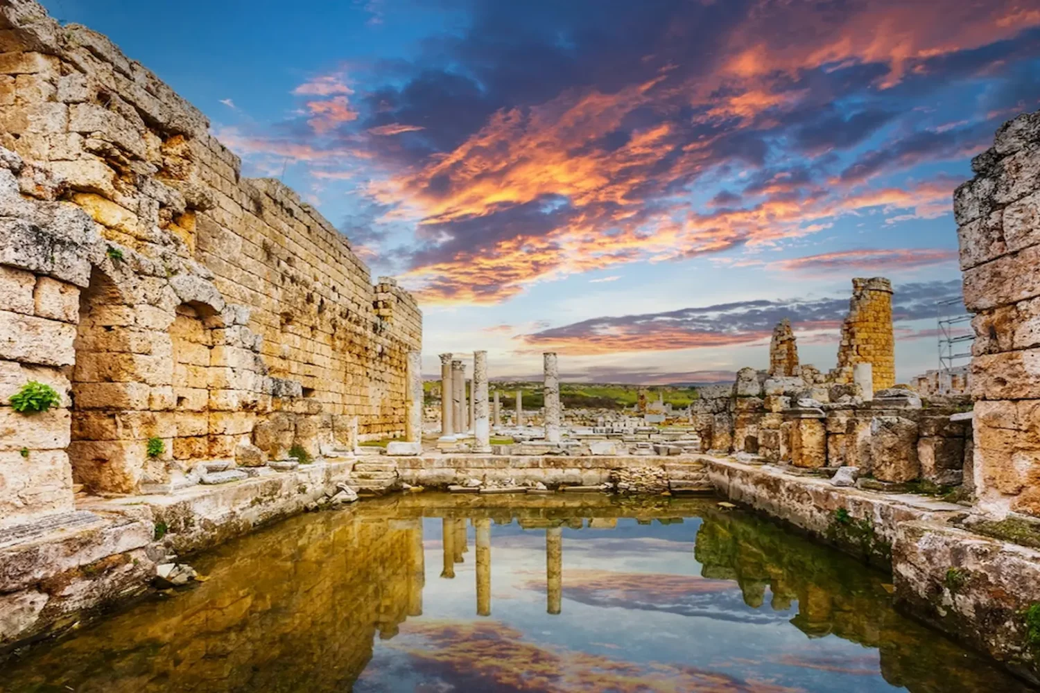 Ancient Roman walls and columns reflected in water at Side Antalya