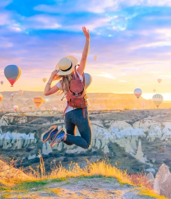 Hot air balloons flying over Uchisar Castle at sunset