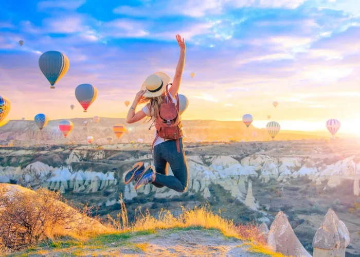 Hot air balloons flying over Uchisar Castle at sunset