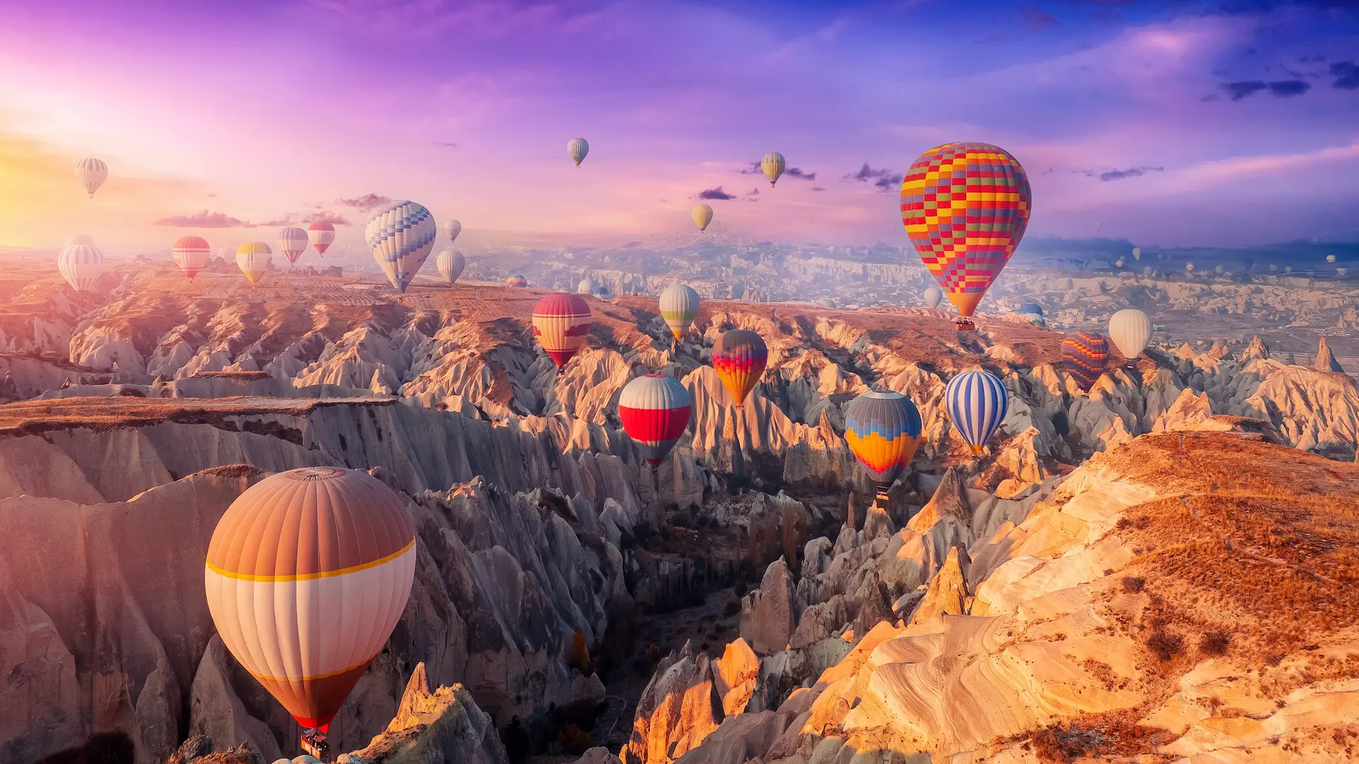 Colorful hot air balloons flying over Cappadocia’s valleys and fairy chimneys at sunrise
