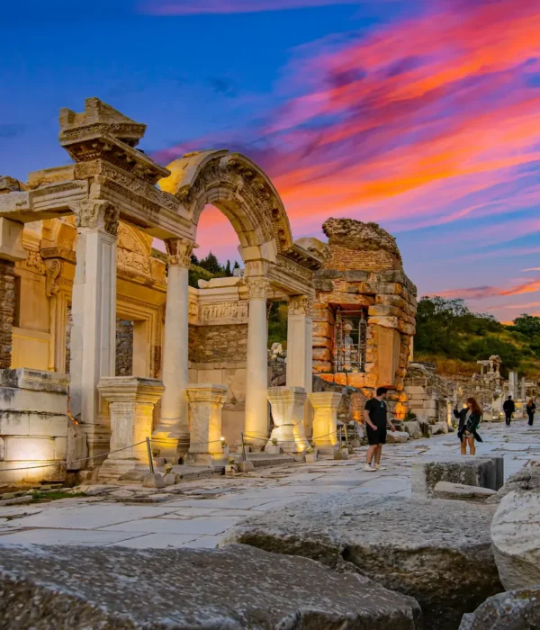 Sunset view of Hadrian’s Temple in Ephesus with tourists walking nearby