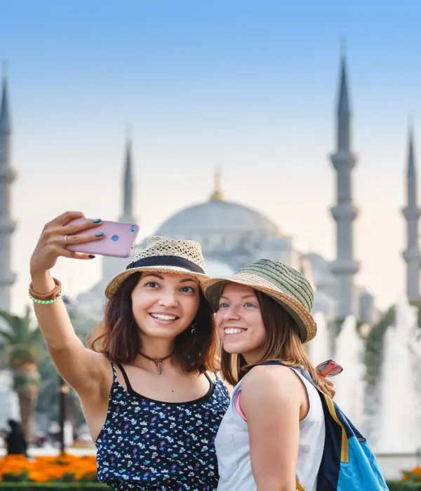 Two travelers taking a selfie in front of the Blue Mosque in Istanbul