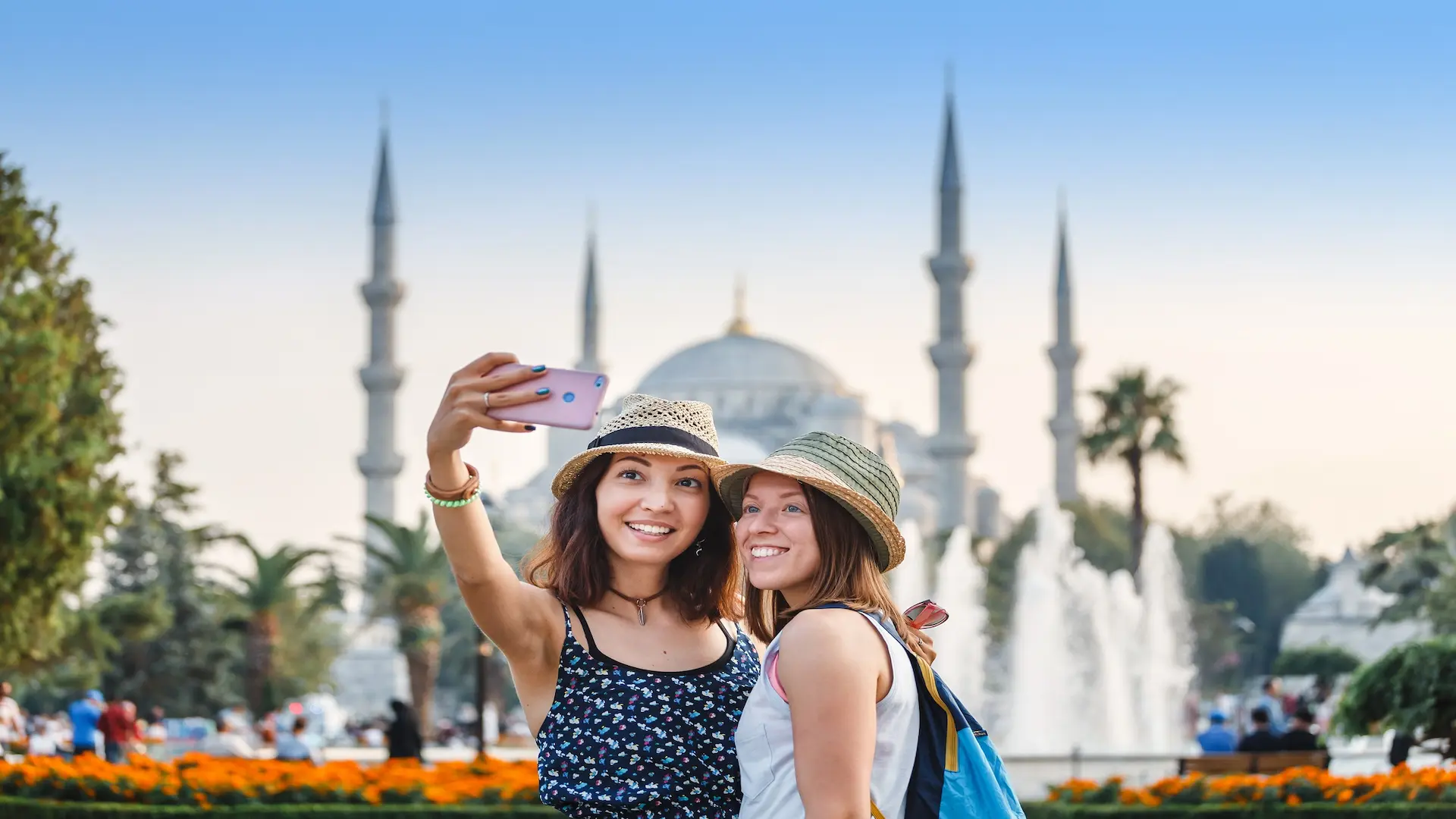 Two travelers taking a selfie in front of the Blue Mosque in Istanbul