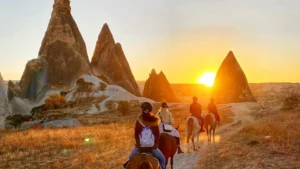 Travelers enjoying a horseback riding tour at sunset in Cappadocia, Turkey