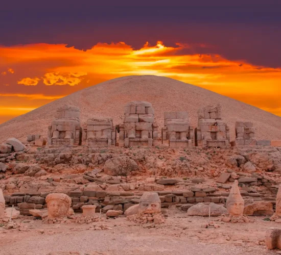 Sunset behind ancient statue heads on Nemrut Mount archaeological site