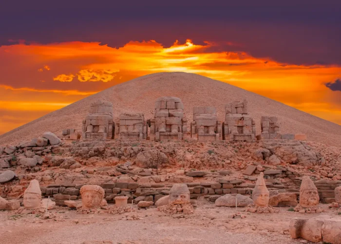Sunset behind ancient statue heads on Nemrut Mount archaeological site
